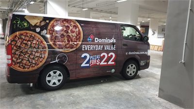 Delivery vehicle carrying printed wrap graphics along its body
